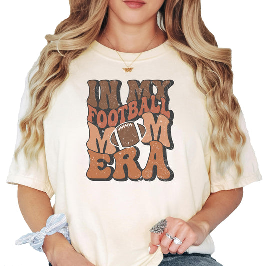 Ivory 'In My Football Mom Era' graphic t-shirt with vintage-style text design, front view