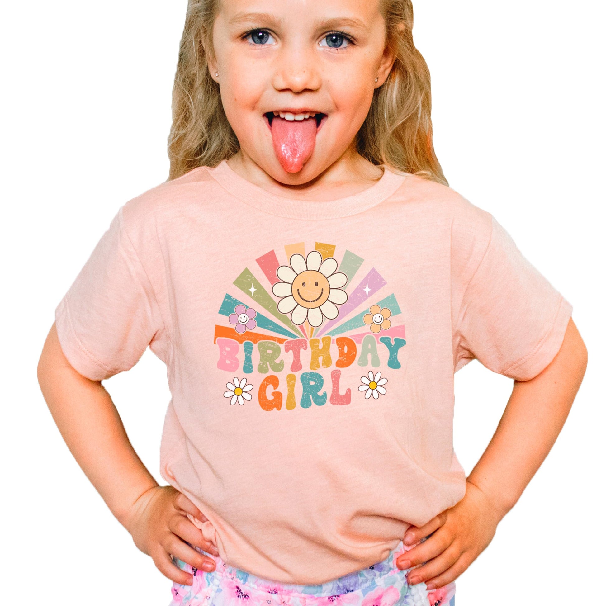 Peach birthday girl t-shirt with colorful retro sunbeam graphic laid flat