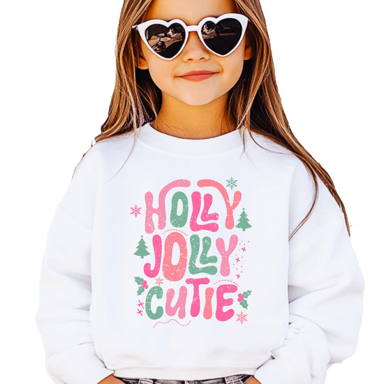 Close-up of Holly Jolly Cutie Christmas sweatshirt graphic with trees, snowflakes, and holly details