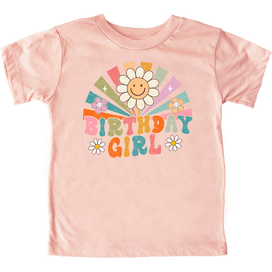Close-up of vibrant rainbow sunbeam and groovy flower design on girls birthday tee