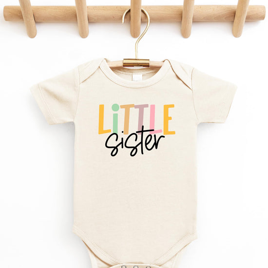 Close-up of Little Sister baby bodysuit print detail on soft natural fabric
