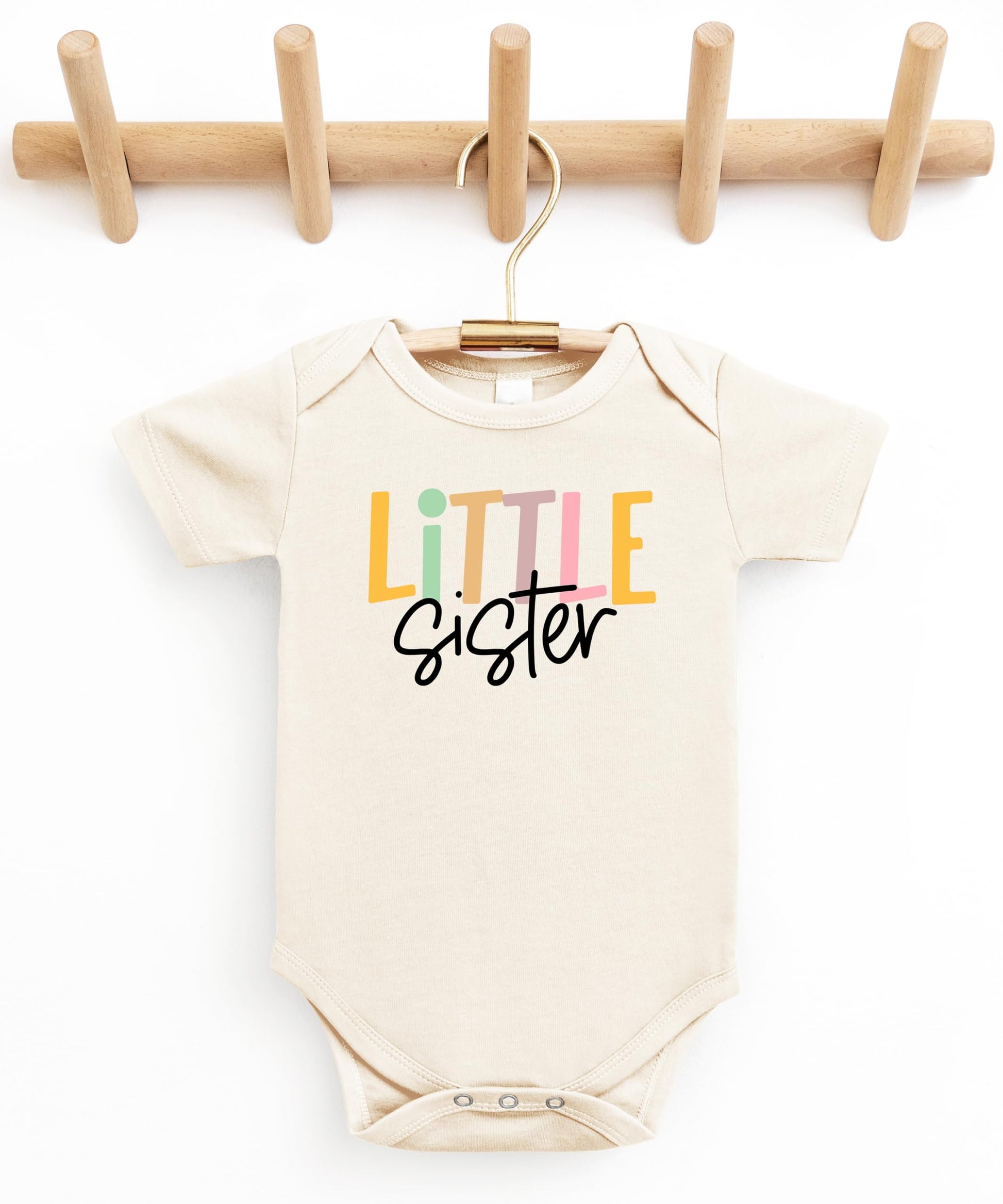 Close-up of Little Sister baby bodysuit print detail on soft natural fabric