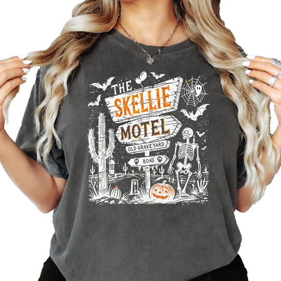 Close-up of Skellie Motel Halloween graphic tee print detail with skeleton, pumpkins, and retro motel sign