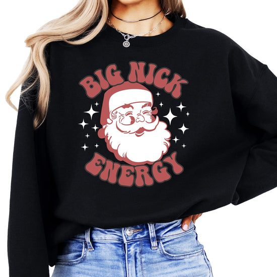 Women's black pullover sweatshirt with retro Big Nick Energy Santa graphic by Olive Loves Apple