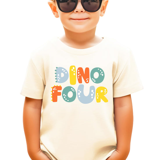 Close-up of Dino Four birthday tee showing vibrant dinosaur print detail