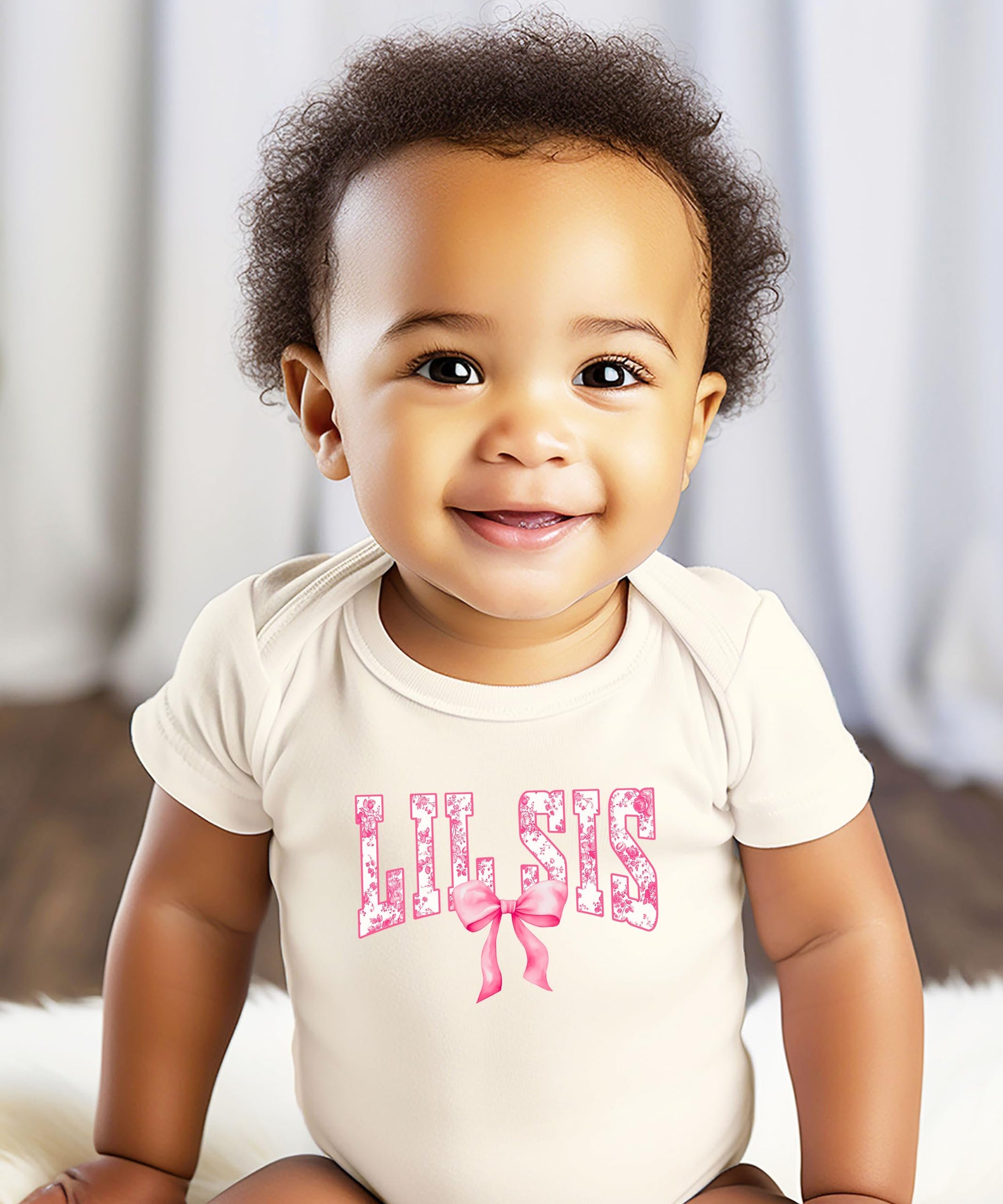 Baby girl wearing Lil Sis natural bodysuit with pink bow floral graphic, newborn outfit