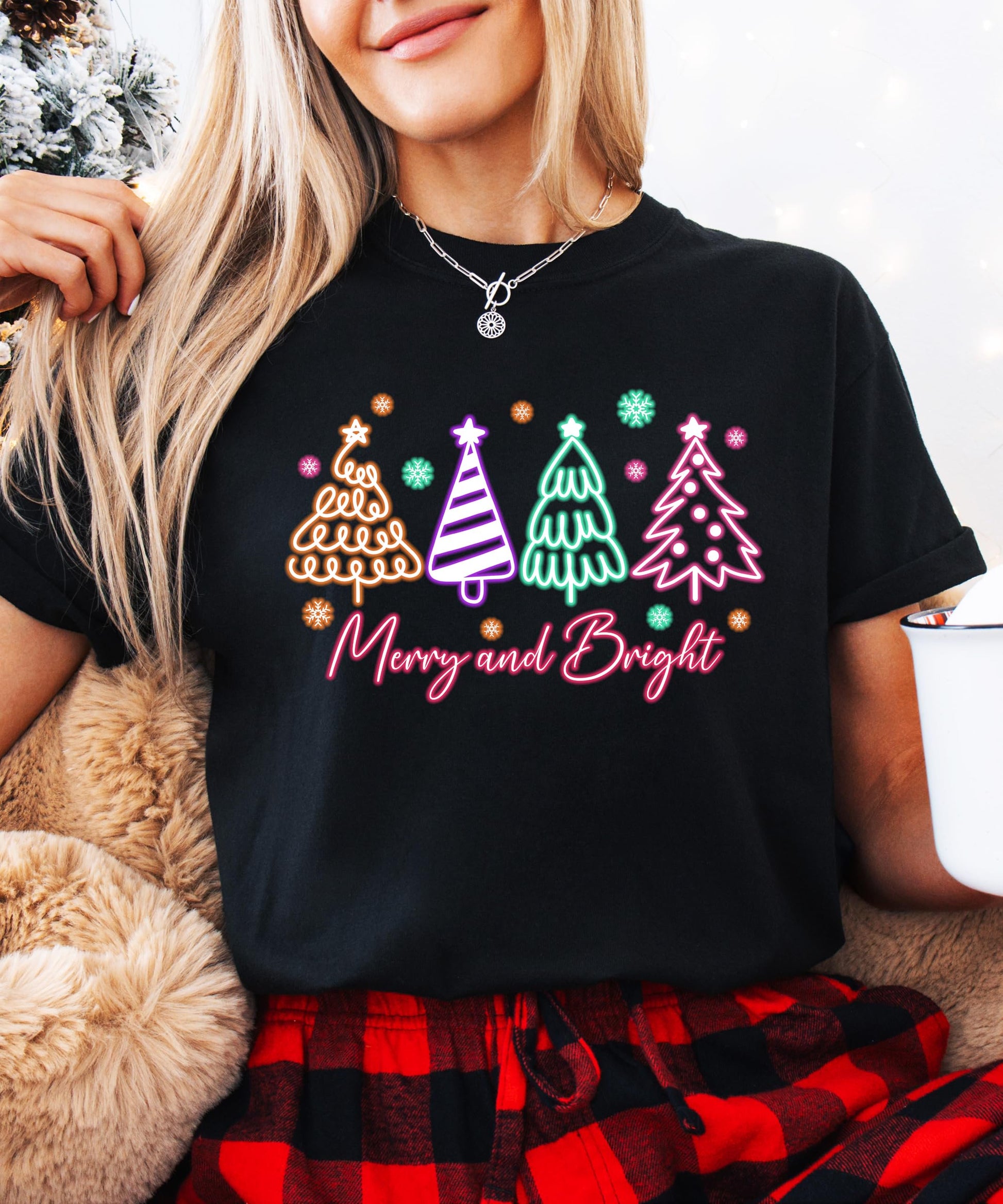 Close-up of vibrant neon Christmas tree design on black holiday graphic shirt