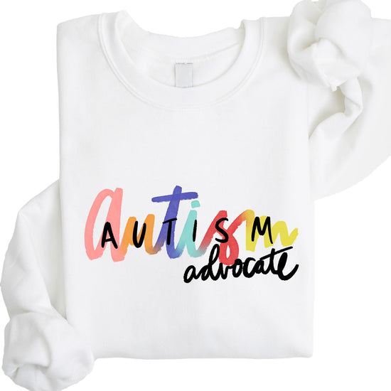 Women's white pullover sweatshirt with colorful Autism Advocate graphic design on the front