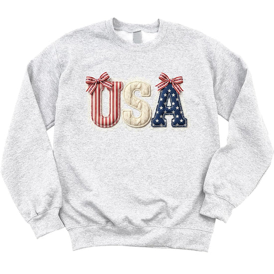 Model wearing white USA bow sweatshirt styled with jeans for July 4th casual look