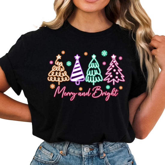 Front view of neon holiday Christmas shirt with glowing tree graphic on black tee