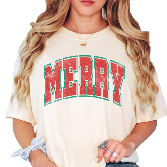 Adult natural color Christmas shirt with bold Merry varsity letters graphic on the front