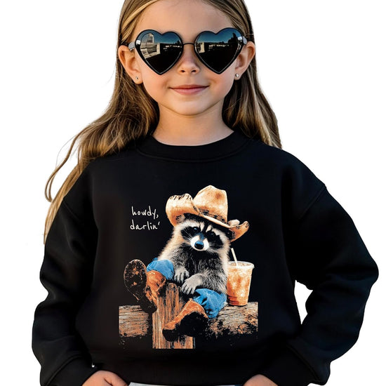 Front view of black unisex crewneck pullover featuring a western-style raccoon cowboy graphic