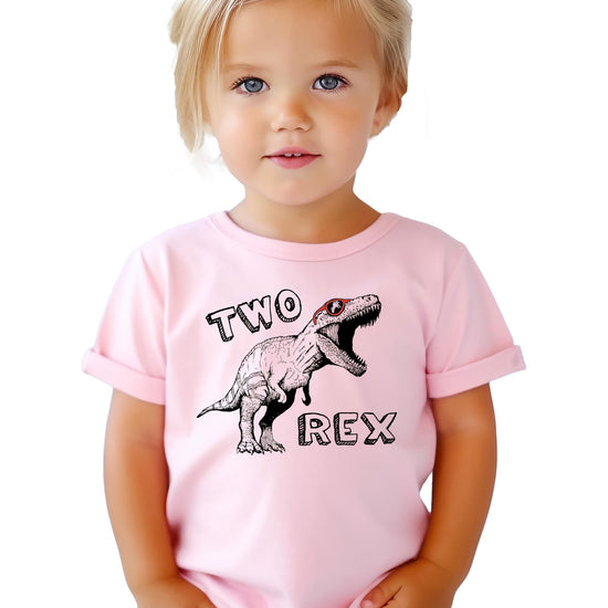 Detail shot of white T-Rex second birthday graphic on mauve toddler t-shirt