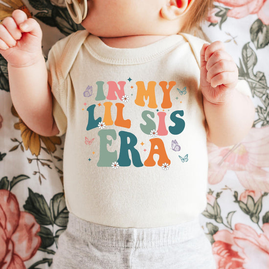 Close-up of butterfly and daisy design on In My Lil Sis Era newborn bodysuit