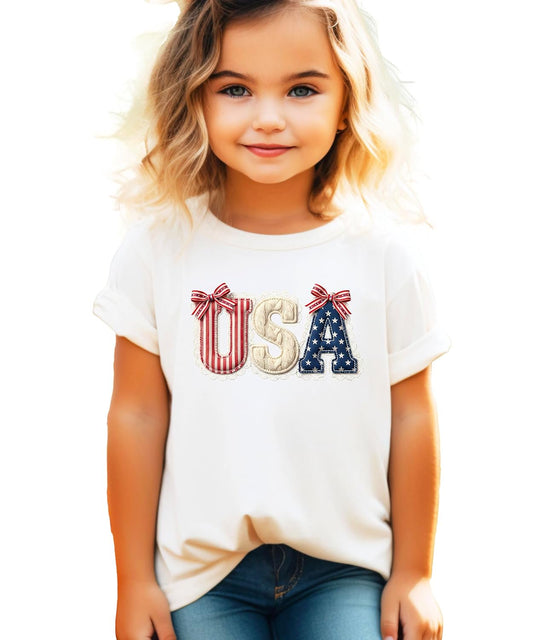 Women's pink USA coquette bow graphic tee with lace trim and red white and blue ribbon bows for 4th of July