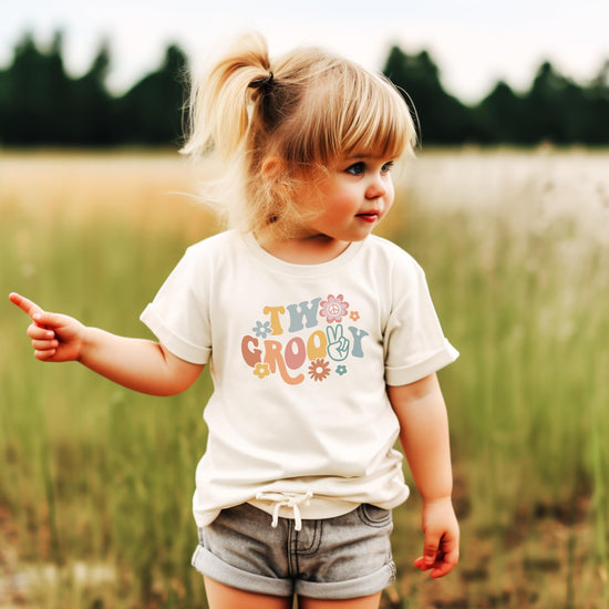 Toddler girl wearing Two Groovy daisy 2nd birthday shirt natural color full outfit