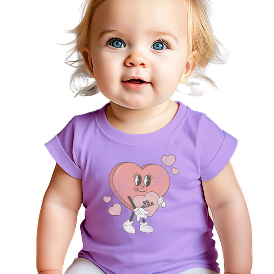 Close-up of Be Mine heart print on pink Valentine's Day shirt for kids