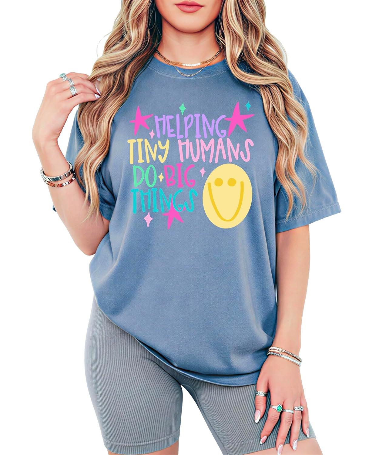 Flat lay of Helping Tiny Humans Do Big Things kindergarten teacher tee showing full design detail and soft garment-dyed fabric