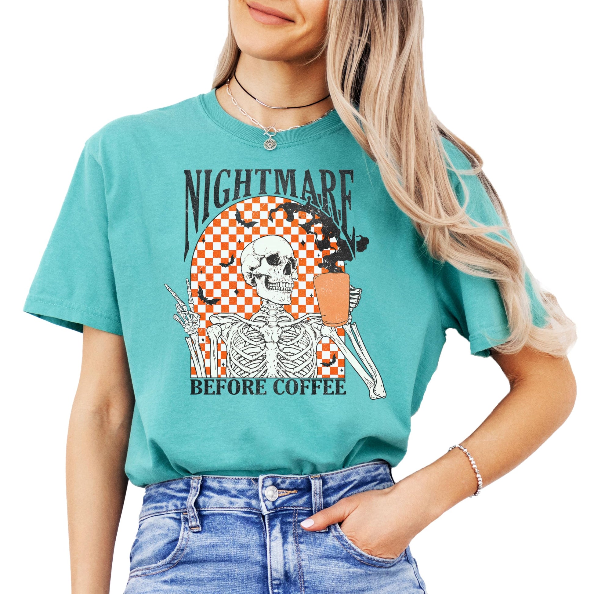 Front view of Nightmare Before Coffee funny retro Halloween tee in seafoam with skeleton and flying bats design