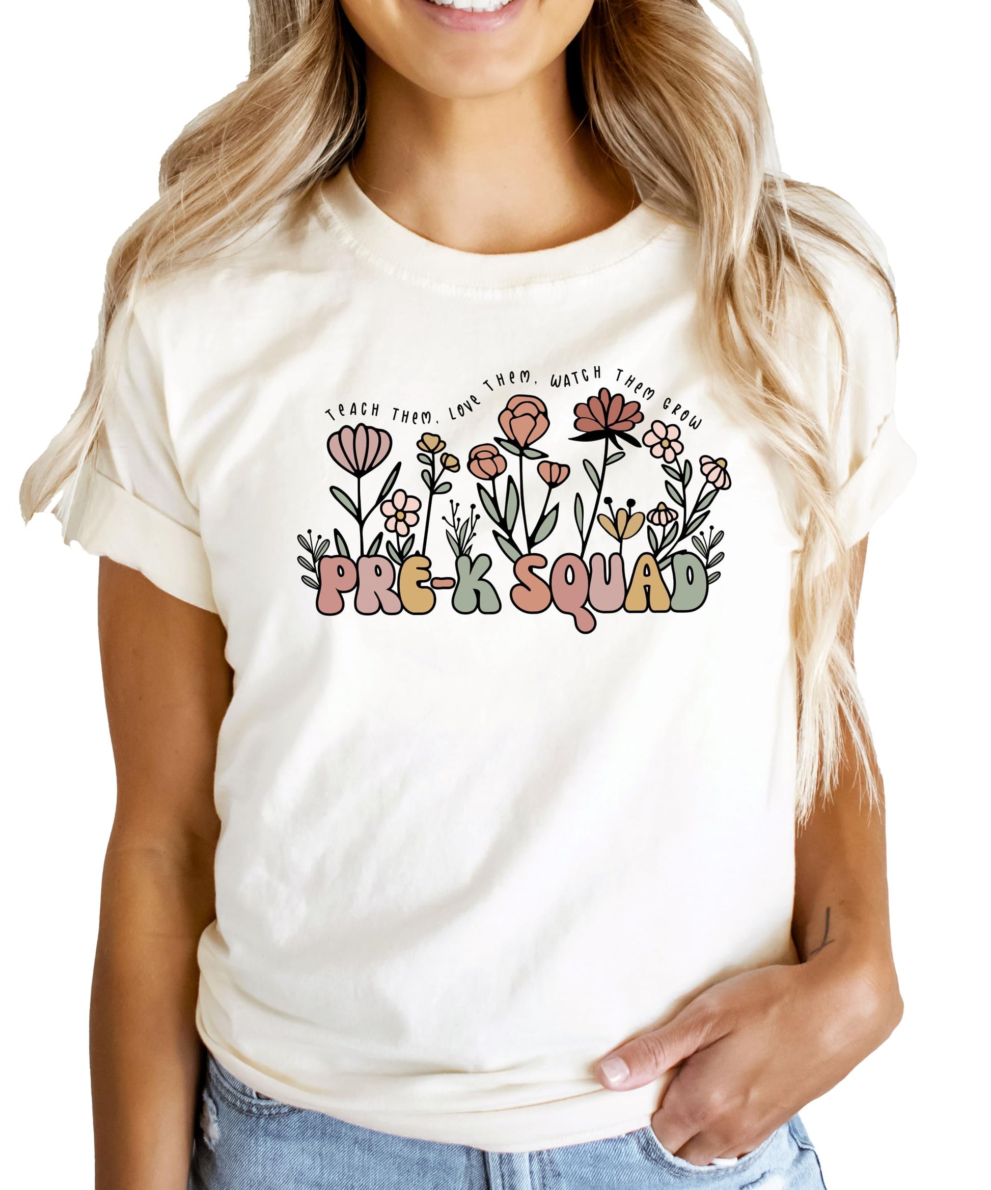 Close-up of retro flower and 'Teach Them Love Them Watch Them Grow' print on peach teacher shirt