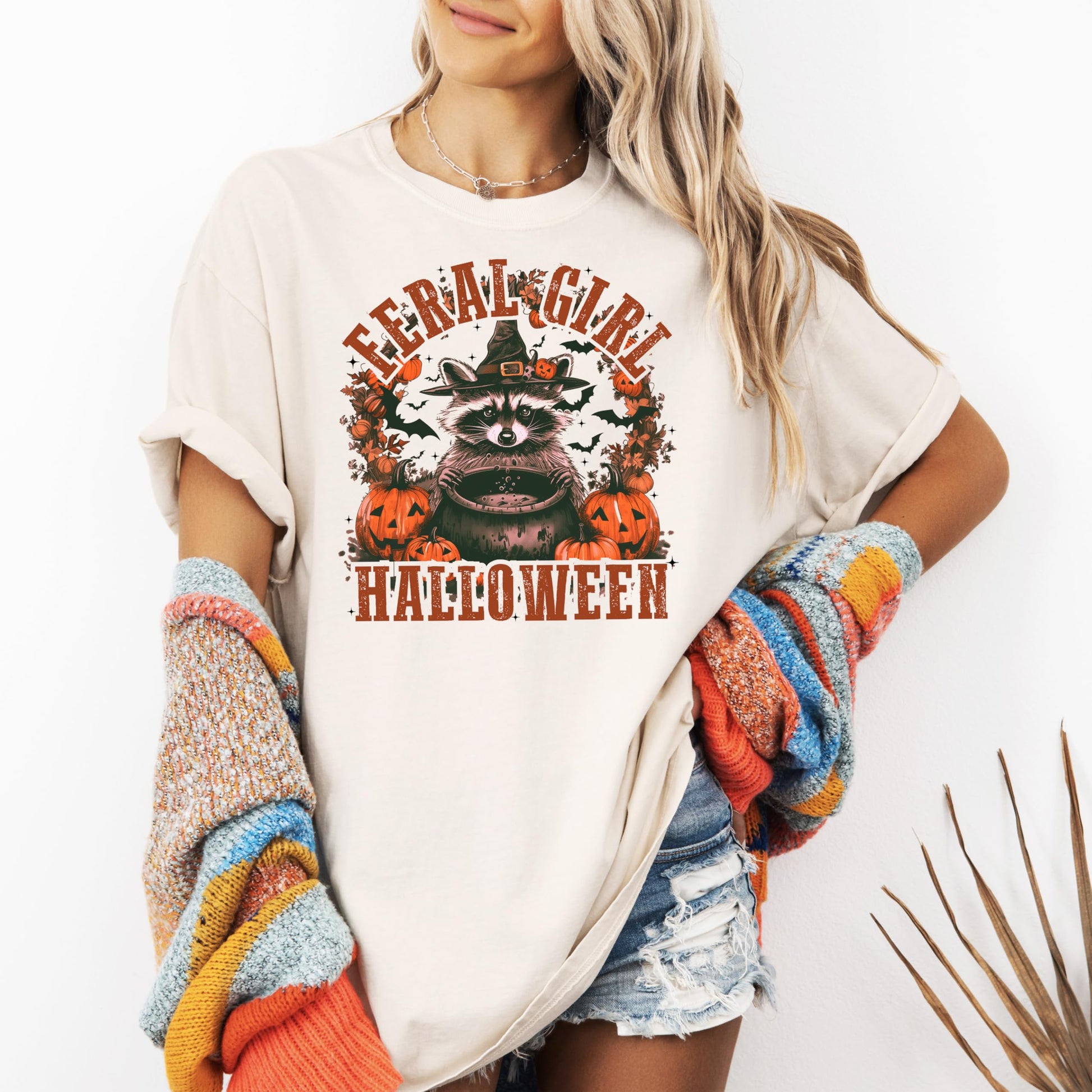 Women's seafoam Halloween graphic tee with playful raccoon and witch hat print detail