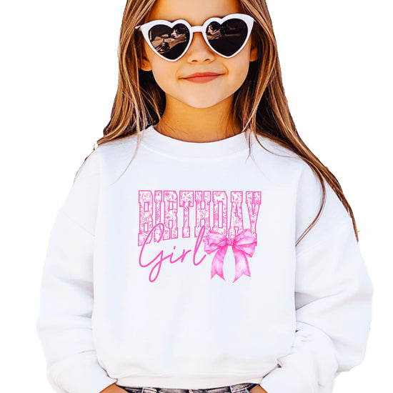 Youth girl wearing Birthday Girl pink bow pullover sweatshirt in party setting