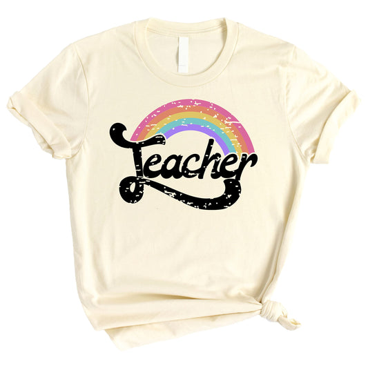 Front view of rainbow teacher shirt on model, bright multicolor graphic on black tee