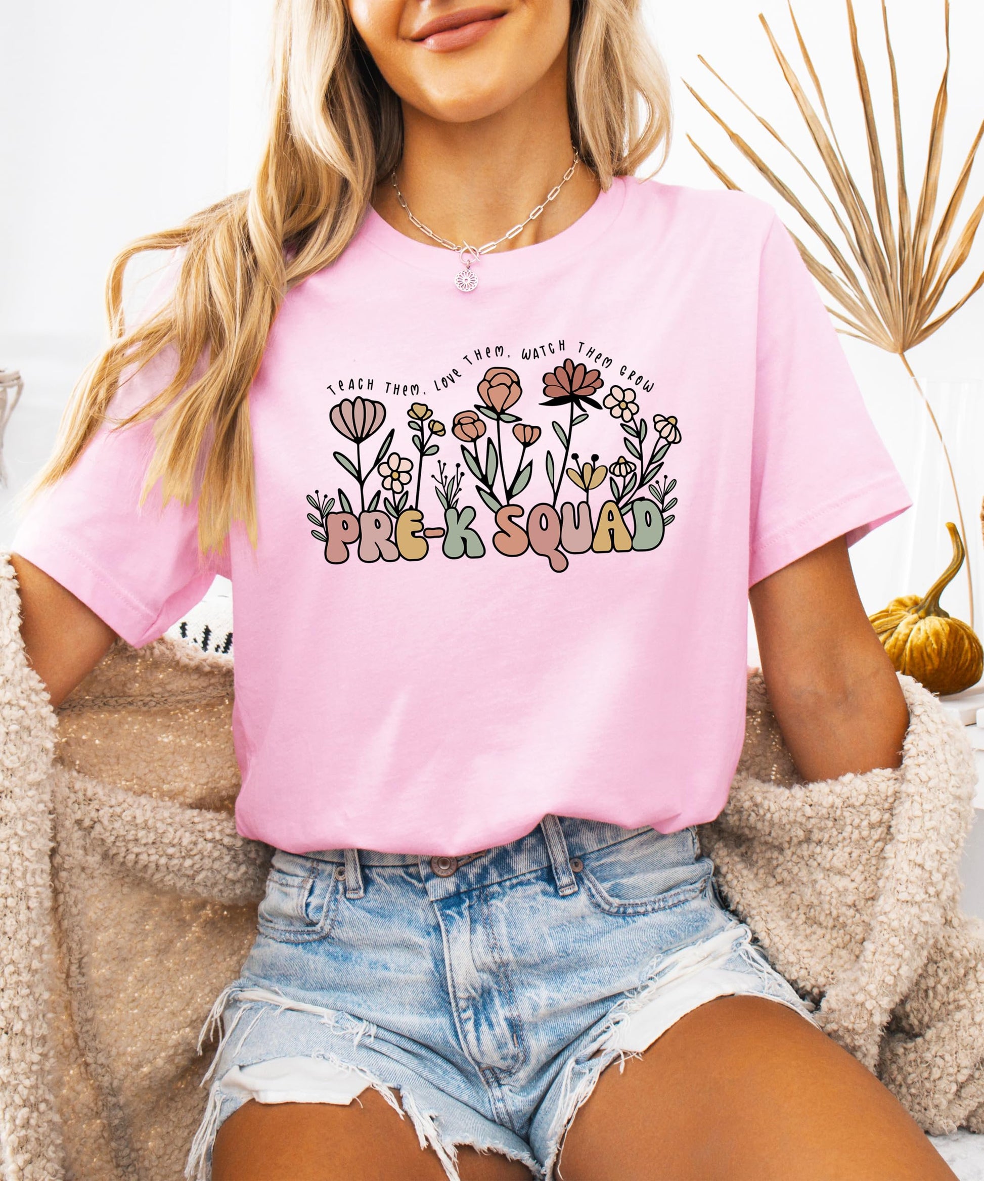Woman wearing Pre-K Squad floral teacher tee in peach casual fit