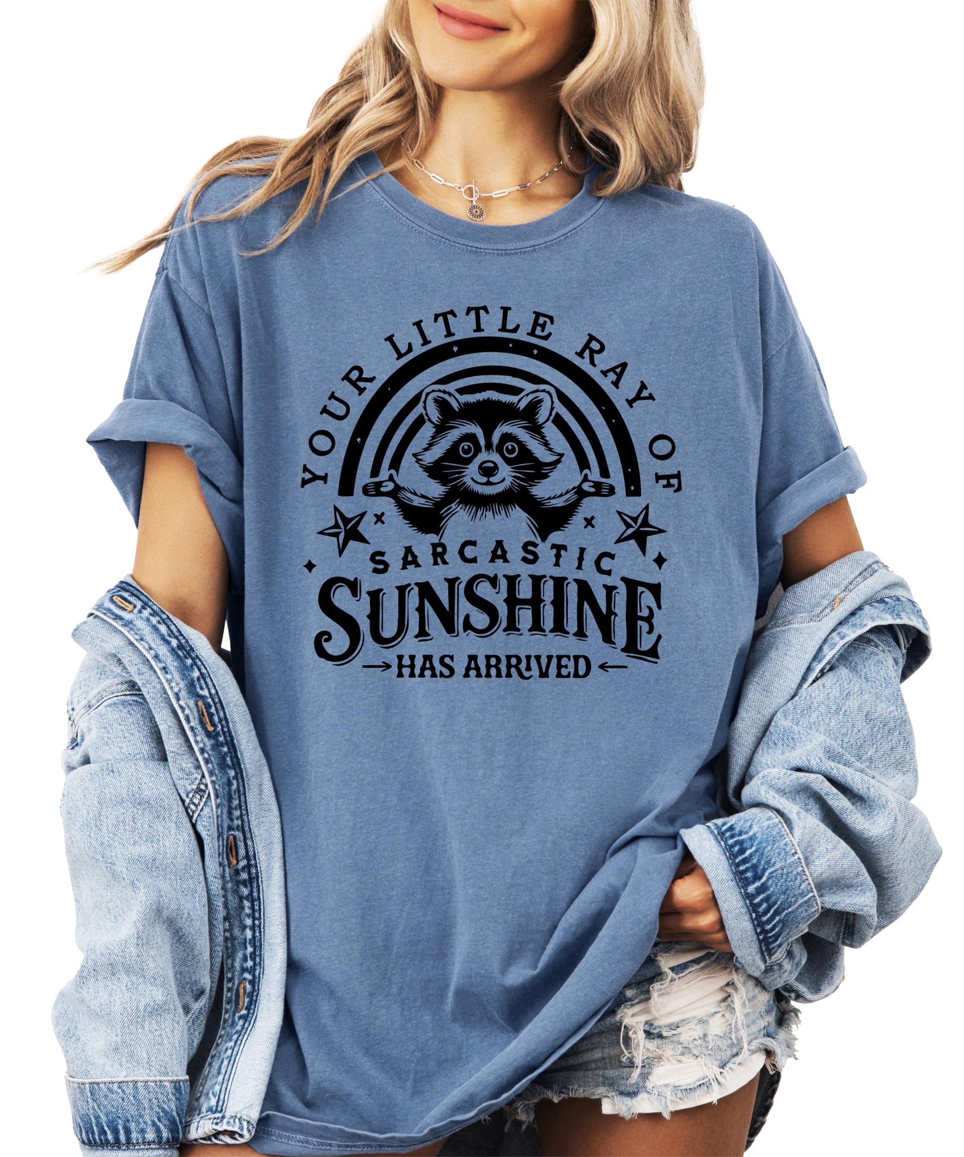 Flat lay of ivory t-shirt showing full raccoon graphic and text design