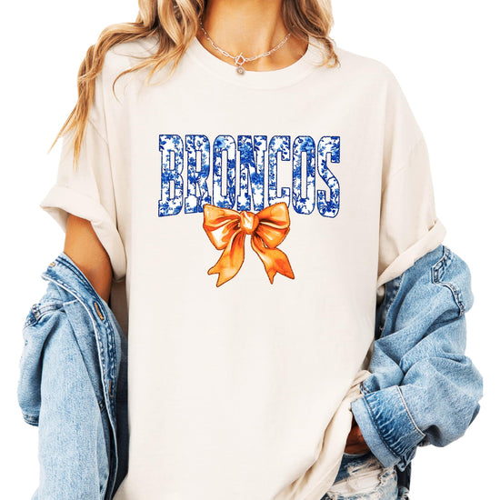 Front view of Broncos fan graphic tee featuring floral-filled team lettering and statement bow