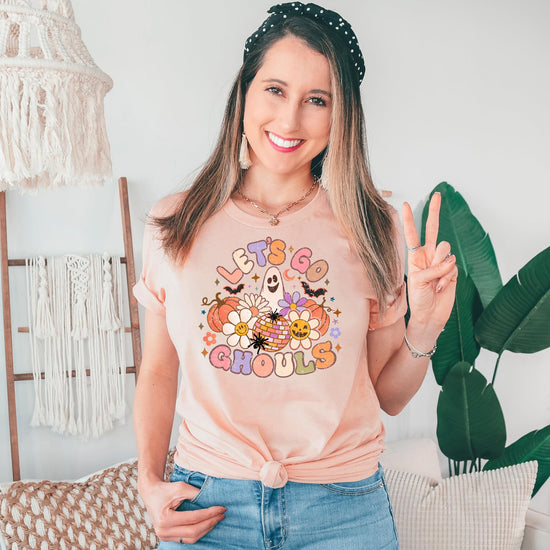 Let's Go Ghouls Halloween shirt laid flat showing full graphic design on peach fabric