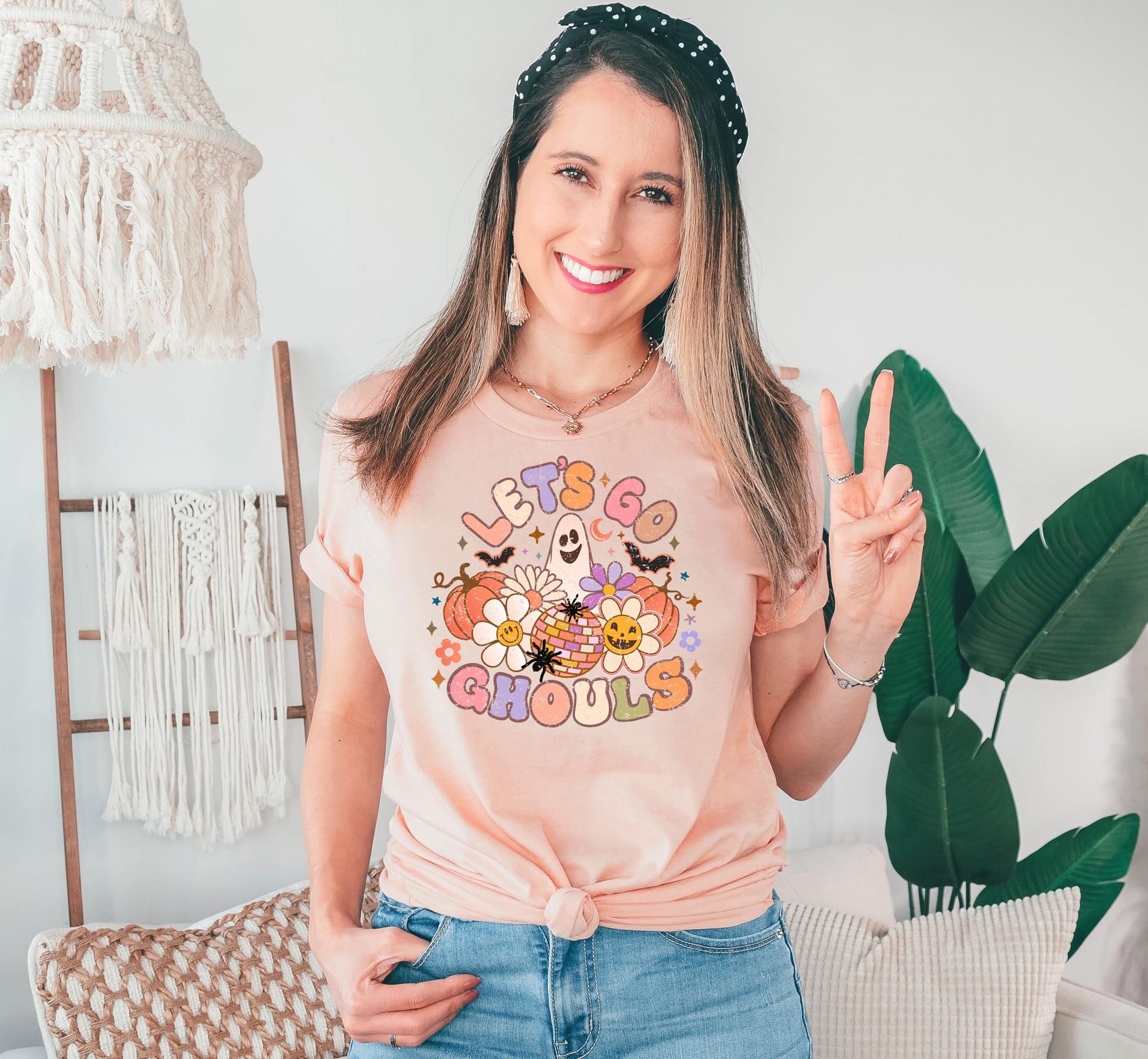 Let's Go Ghouls Halloween shirt laid flat showing full graphic design on peach fabric