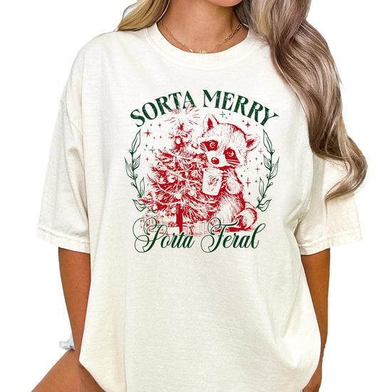 Flat lay of ivory Sorta Merry Sorta Feral women's holiday graphic tee showing full print detail