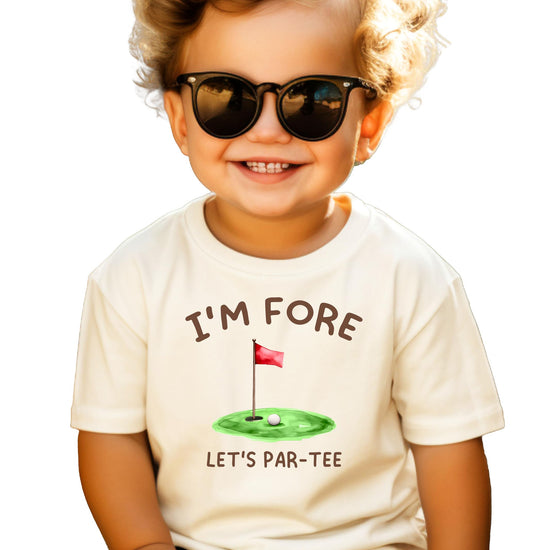 Toddler golf birthday shirt laid flat showing full front graphic and natural fabric color