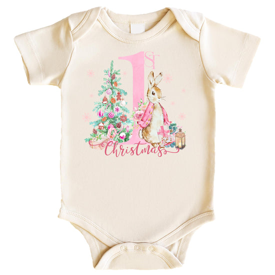 Baby girl wearing a natural-toned First Christmas bunny graphic bodysuit, front view