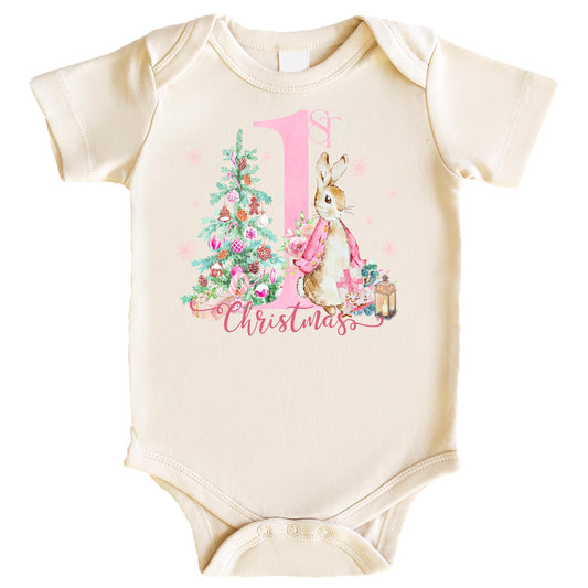 Baby girl wearing a natural-toned First Christmas bunny graphic bodysuit, front view