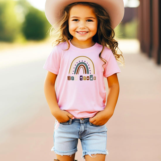 Flat lay of youth pink tee featuring 3rd grade rainbow school graphic
