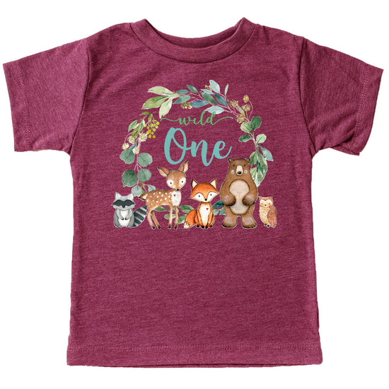 Wild One first birthday t-shirt flat lay showing wreath design with woodland creatures