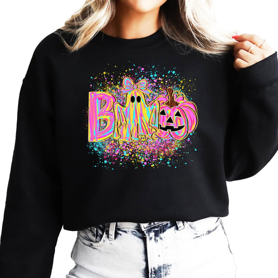 Close-up of neon BOO graphic sweatshirt showing ghost with bow and pumpkin design detail