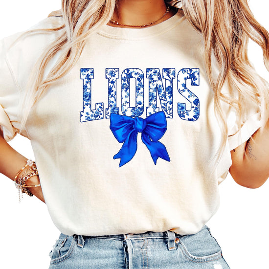 Woman wearing ivory Lions school spirit tee with floral graphics