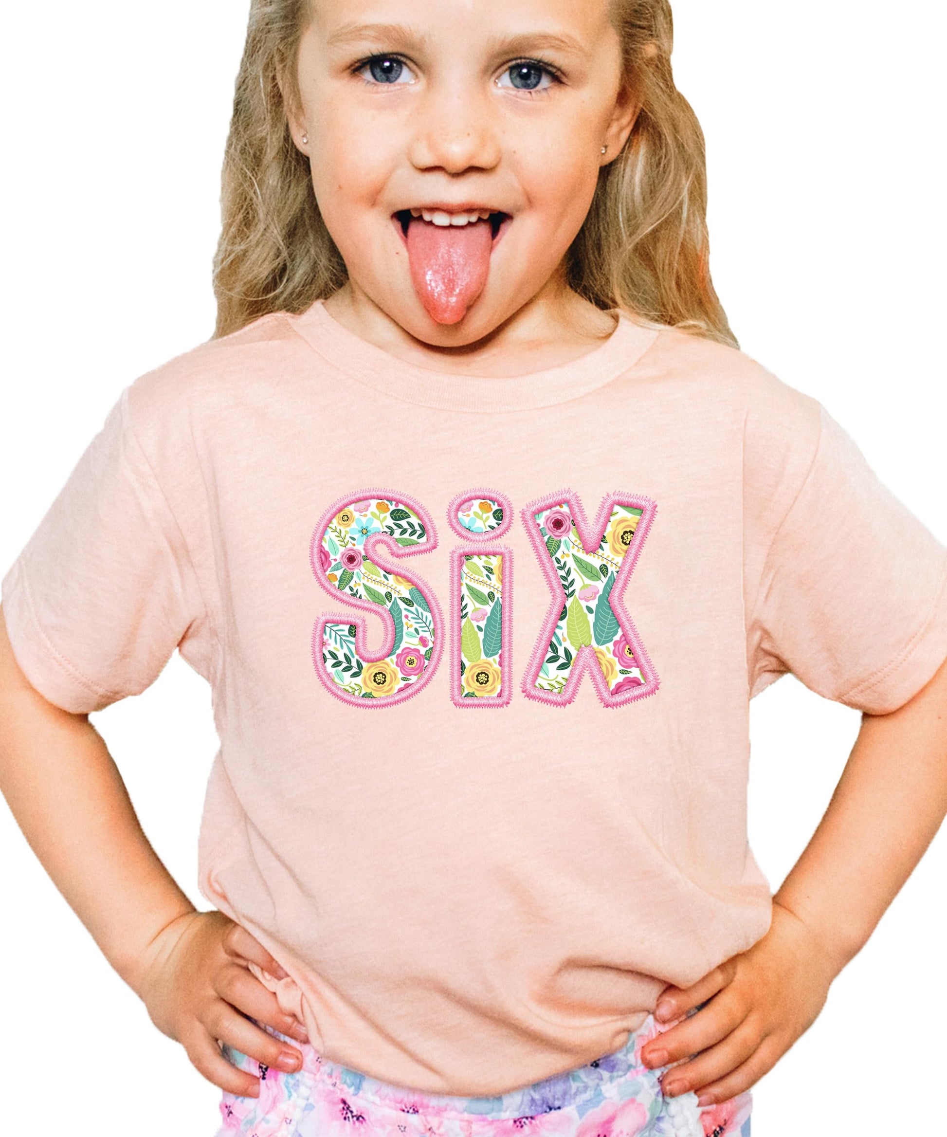 Girls wearing peach sixth birthday shirt with colorful floral number six graphic print