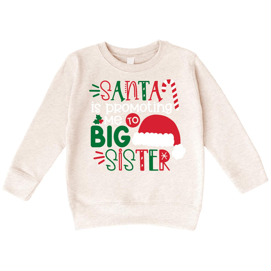 Front view of kids Christmas sweatshirt featuring a Santa 'Promoted to Big Sister' graphic design