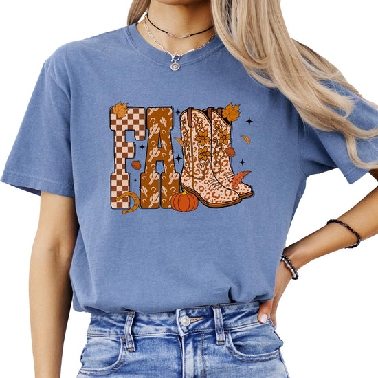Flat lay of Olive Loves Apple seafoam fall cowgirl shirt with boots, pumpkins, and leaves design