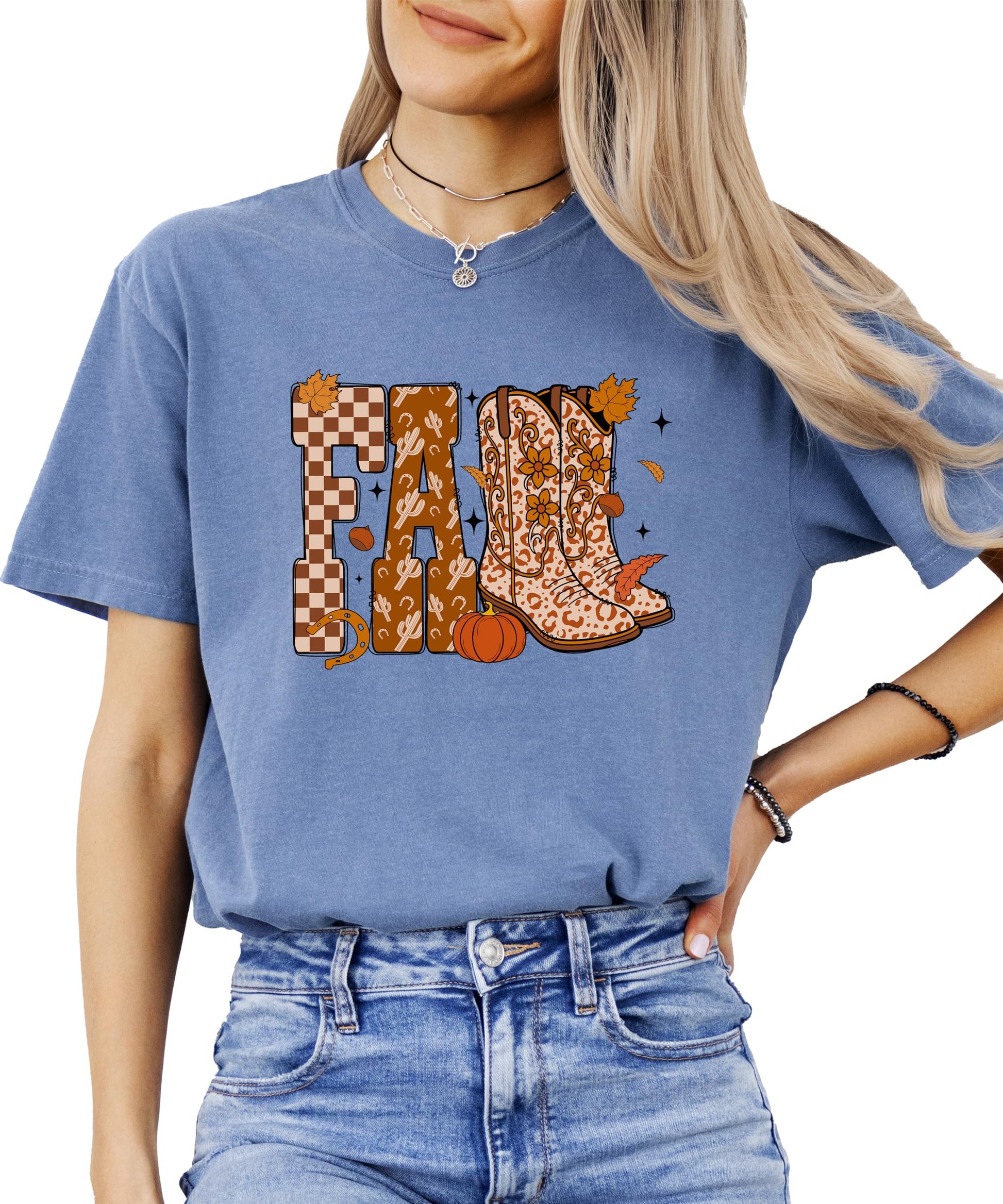 Flat lay of Olive Loves Apple seafoam fall cowgirl shirt with boots, pumpkins, and leaves design