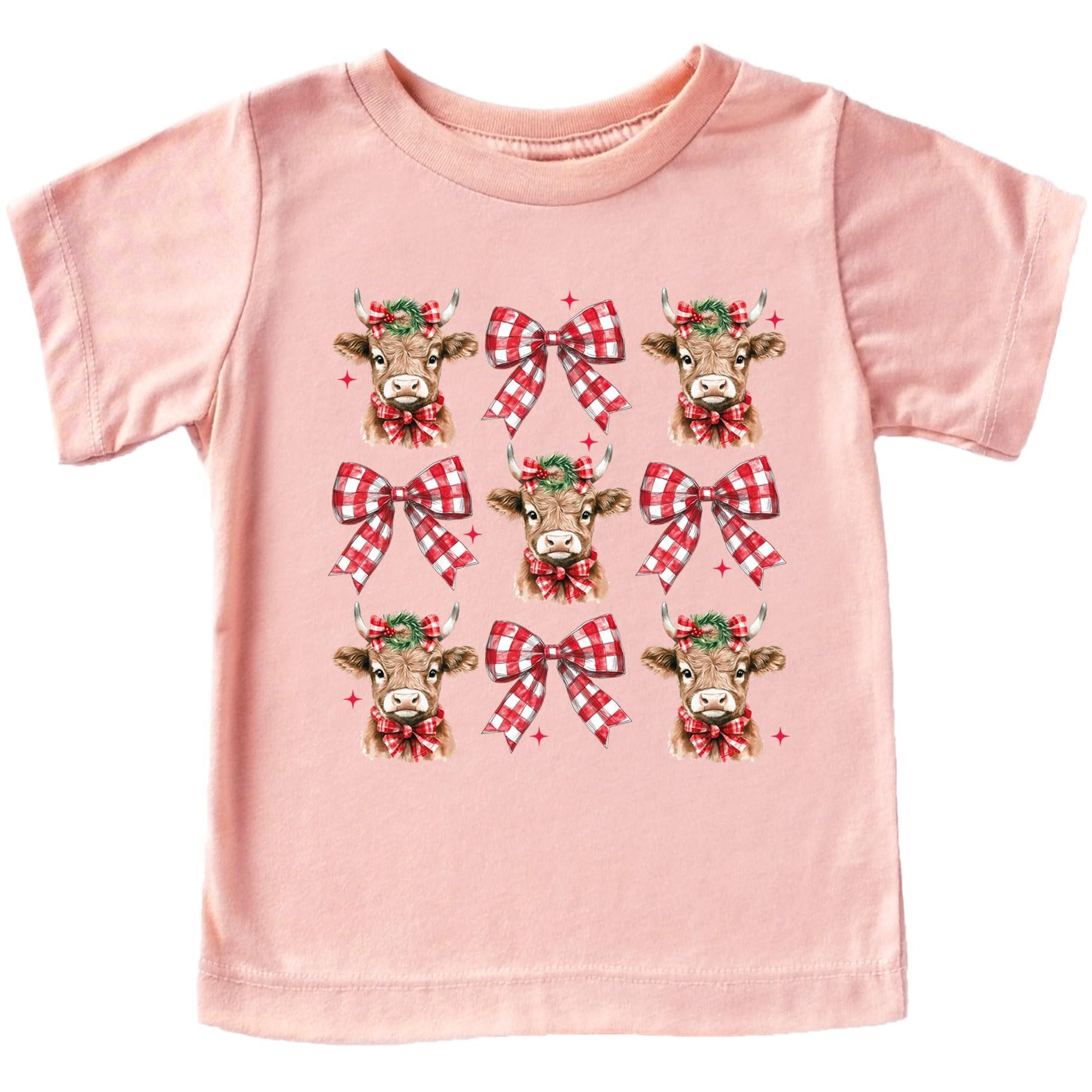Close-up of Christmas cow and plaid bow graphic print on soft peach tee