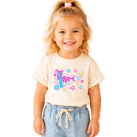 Close-up of Pre-K pennant graphic with hand-drawn bow, retro face, daisies, and sparkle stars on girls tee