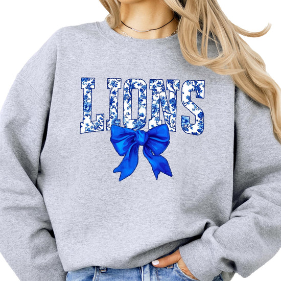 Detail shot of coquette bow accent on blue floral Lions team sweatshirt