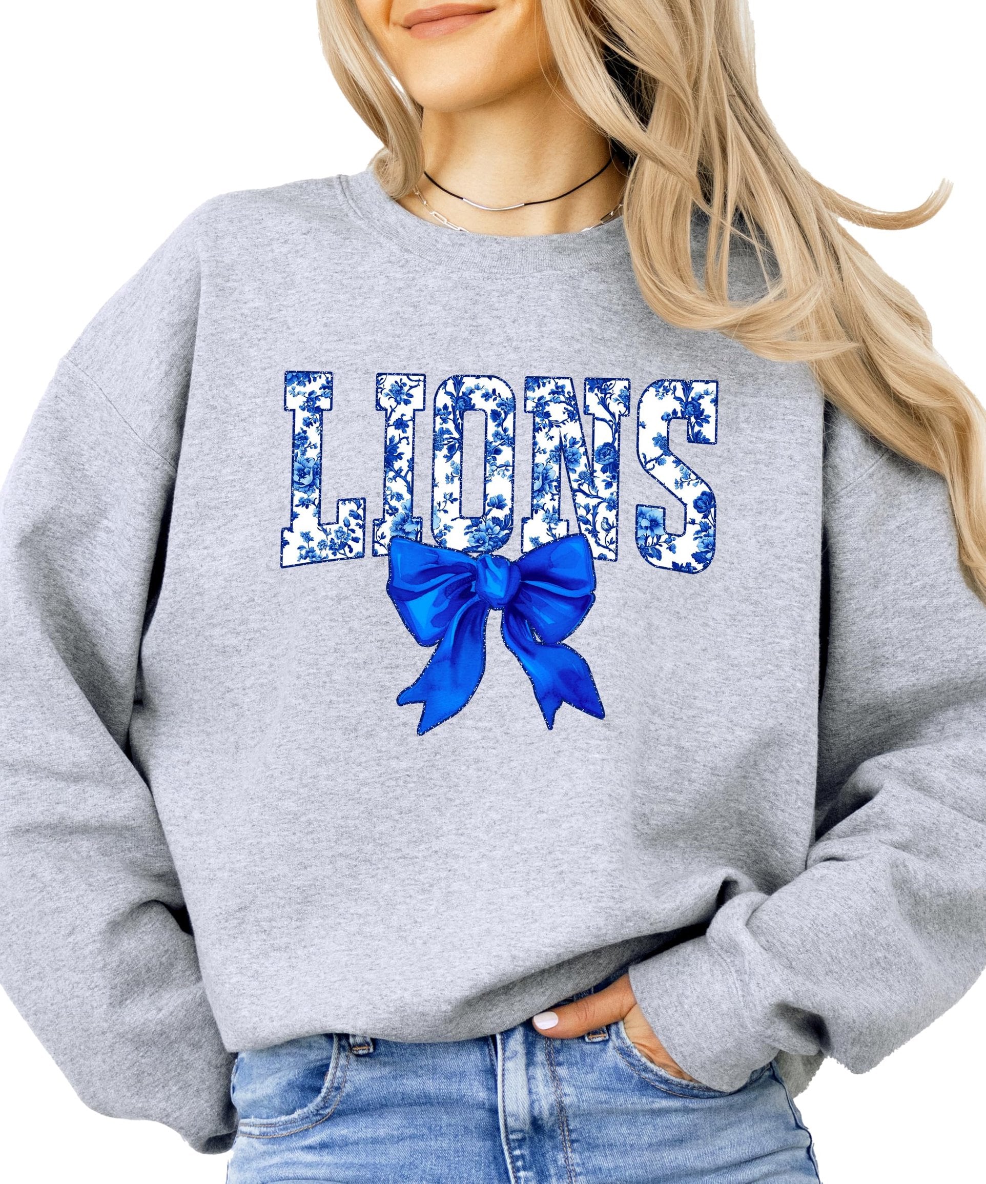 Detail shot of coquette bow accent on blue floral Lions team sweatshirt