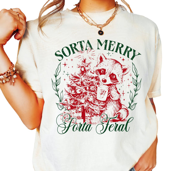 Ivory women's Christmas tee with a funny raccoon graphic and the words Sorta Merry Sorta Feral